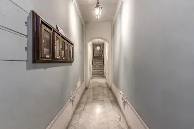 a long hallway with a stairway with a light on the wall at Monti Studio Roman Forum in Rome
