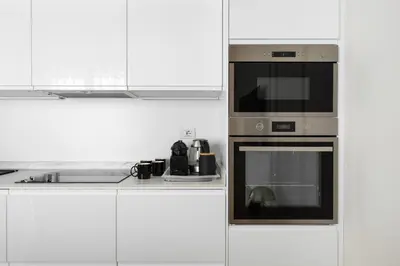 a kitchen with a microwave and a stove at Vittorio Emanuele Grand Apartment in Rome