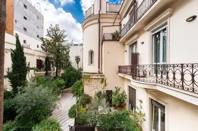 an alley between two buildings with balconies and plants at Vittorio Emanuele Grand Apartment in Rome