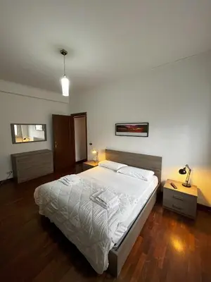 a bedroom with a large white bed and wooden floors at Moonlight Vatican by ACS HOLIDAYS in Rome