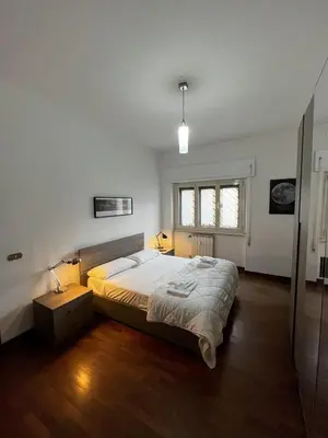 a bedroom with a large bed in a room with wooden floors at Moonlight Vatican by ACS HOLIDAYS in Rome