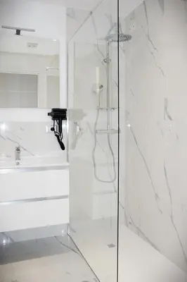 a white bathroom with a shower and a sink at Domus Dea Roma by Trinità in Rome