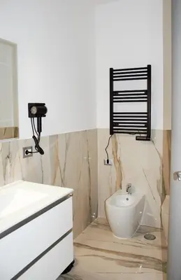 a white bathroom with a sink and a mirror at Domus Dea Roma by Trinità in Rome