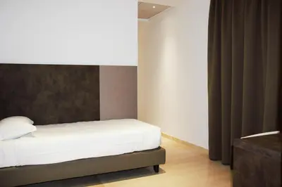 a bedroom with a bed with white sheets and a table at Domus Dea Roma by Trinità in Rome