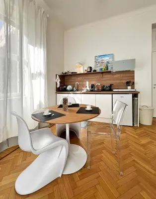 a dining room with a table and white chairs at Roma Parioli - Suite Mediterranea in Rome