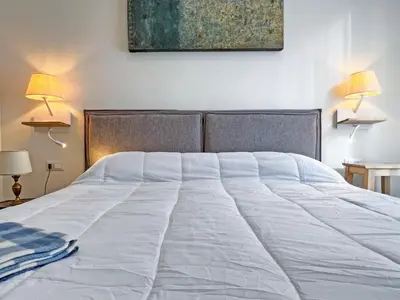 a large white bed in a bedroom with two lamps at Roma Parioli - Suite Mediterranea in Rome