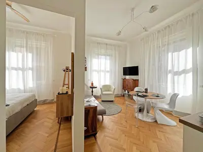 a bedroom with a bed and a living room with a table at Roma Parioli - Suite Mediterranea in Rome