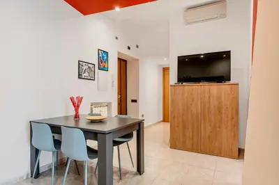 a dining room with a table and chairs and a flat screen tv at Appartamento Amy House in Rome