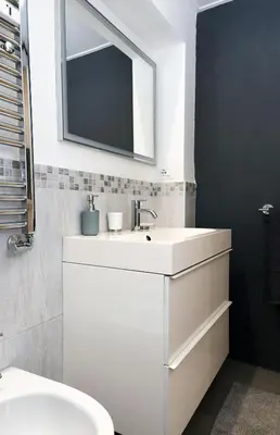 a white bathroom with a sink and a mirror at Casetta Garbatella in Rome