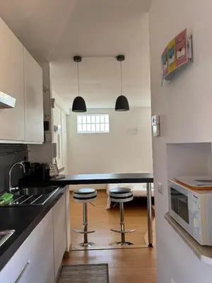 a kitchen with a black counter and two stools at Splendido Attico con Terrazza a Trastevere in Rome