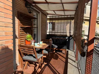 a patio with a table and chairs on a balcony at Splendido Attico con Terrazza a Trastevere in Rome