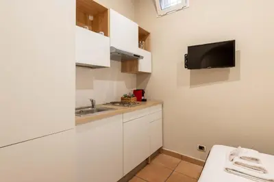 a kitchen with a sink and a tv on the wall at Loft nel Cuore della Capitale in Rome