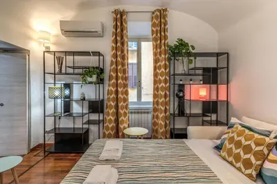 a living room with a bed and a window at Fresh House Sapienza in Rome