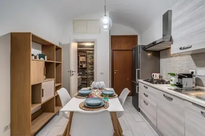 a kitchen with a table and chairs in a room at Fresh House Sapienza in Rome