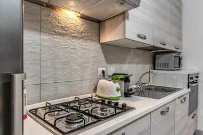 a kitchen with a stove top oven next to a sink at Fresh House Sapienza in Rome