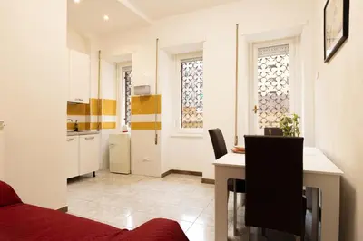 a living room with a red couch and a kitchen at Alma Musa Piazza Bologna Apartment in Rome
