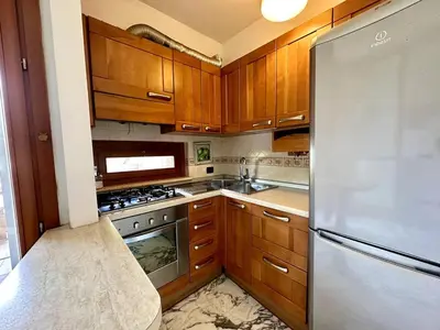 a kitchen with wooden cabinets and a stainless steel refrigerator at The Vatican Studio in Rome
