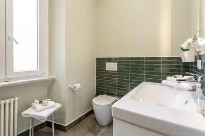 a white bathroom with a toilet and a sink at iFlat Vatican New Bright & Comfy 3 Bedroom apt in Rome