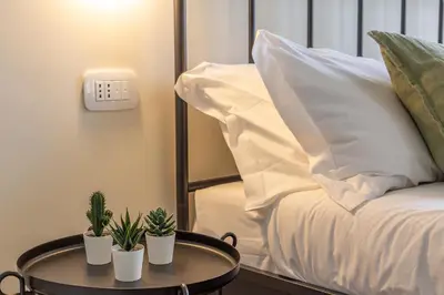 a bedroom with a bed and two potted plants on a table at iFlat Vatican New Bright & Comfy 3 Bedroom apt in Rome