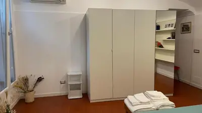 a living room with a white cabinet and a table at Appia apartment in Rome
