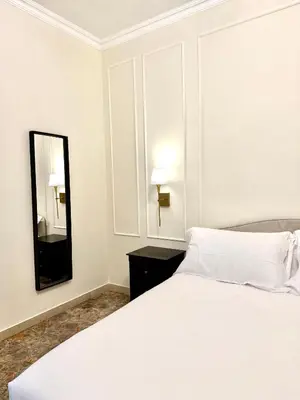 a bedroom with a white bed and a mirror at SarHome in Rome