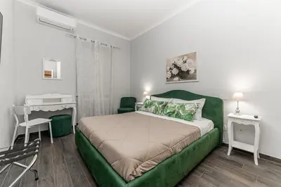 a bedroom with a green bed and a desk at Francesca Suite - Metro Basilica San Paolo in Rome