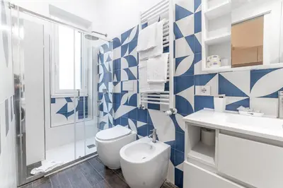 a blue and white bathroom with a toilet and a sink at Francesca Suite - Metro Basilica San Paolo in Rome