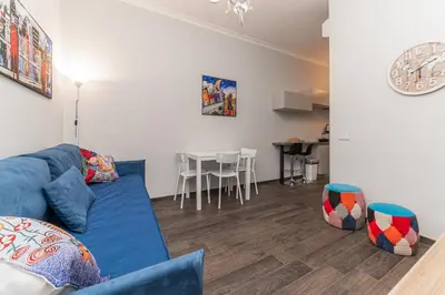 a living room with a blue couch and a table at Francesca Suite - Metro Basilica San Paolo in Rome