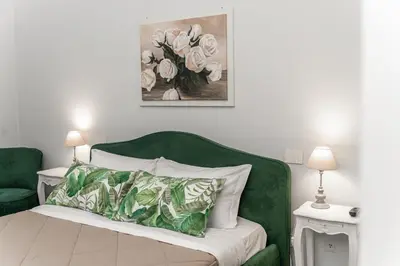 a bedroom with a green chair and a bed with a pillow at Francesca Suite - Metro Basilica San Paolo in Rome
