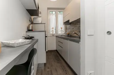 a kitchen with white cabinets and a counter top at Francesca Suite - Metro Basilica San Paolo in Rome