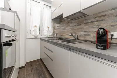 a kitchen with white cabinets and a sink at Francesca Suite - Metro Basilica San Paolo in Rome