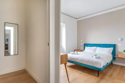 a bedroom with a blue bed and a mirror at iFlat Rome Dream, New Cozy & Chic Apartment in Rome