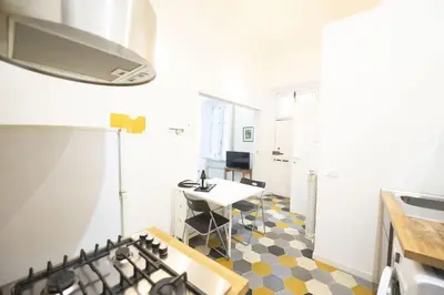 a kitchen with a stove and a desk in a room at Eclectic Apartment in Trendy San Lorenzo in Rome