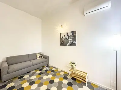 a living room with a couch and a checkered floor at Eclectic Apartment in Trendy San Lorenzo in Rome