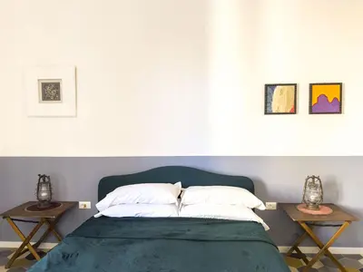 a bedroom with a bed with two side tables at Eclectic Apartment in Trendy San Lorenzo in Rome