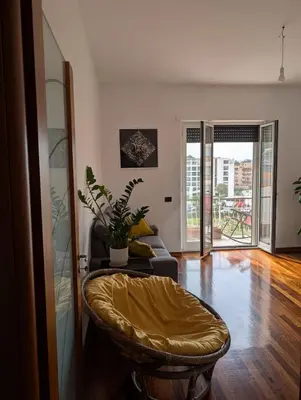 a living room with a couch and a chair at Spacious and silent two-bedroom apartment in Tor Marancia in Rome