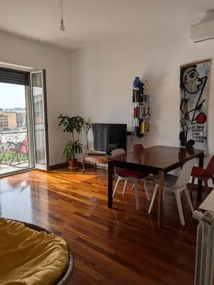 a living room with a table and a couch at Spacious and silent two-bedroom apartment in Tor Marancia in Rome