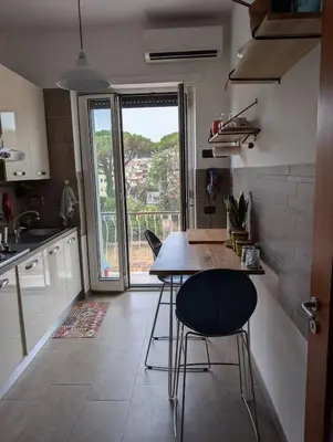 a kitchen with a table and chairs and a window at Spacious and silent two-bedroom apartment in Tor Marancia in Rome