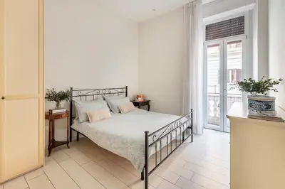 a bedroom with a bed and a large window at Green apartment Rome in Rome