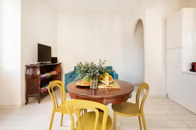 a dining room with a table and yellow chairs at Green apartment Rome in Rome