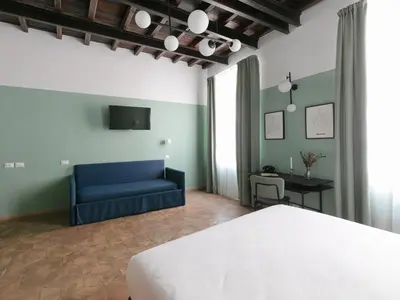 a bedroom with a bed and a blue couch at Off in Rome
