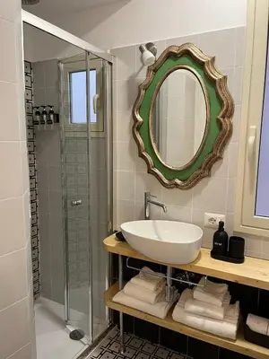 a bathroom with a sink and a shower with a mirror at Suite Crescenzio in Laterano in Rome