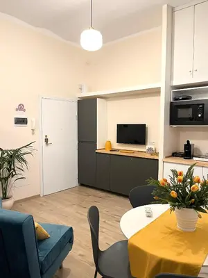 a living room with a table and a kitchen at Suite Crescenzio in Laterano in Rome