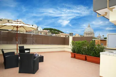 a patio with chairs and an umbrella on a roof at L'Isola di Esme in Rome