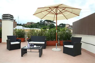 a patio with an umbrella and chairs and a table at L'Isola di Esme in Rome