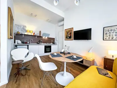 a living room with a table and chairs and a kitchen at Roma Parioli Suite Green Harmony in Rome
