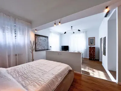 a white bedroom with a bed and a television at Roma Parioli - Loft Style in Rome