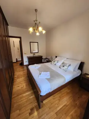 a bedroom with a large bed and a chandelier at Al Gondar 7 Libia Roma in Rome