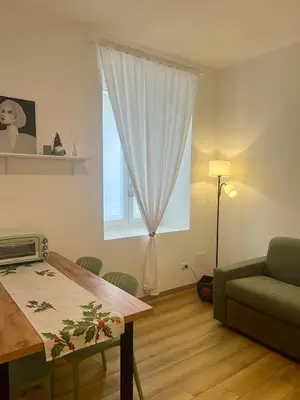 a living room with a green couch and a table at Al lotto 27 Garbatella Storica in Rome