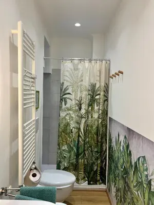 a bathroom with a shower curtain with palm trees at Al lotto 27 Garbatella Storica in Rome